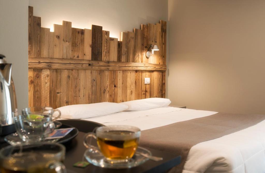 奥斯塔蒙特艾米流斯酒店的一间卧室配有一张床和一张桌子,备有饮料