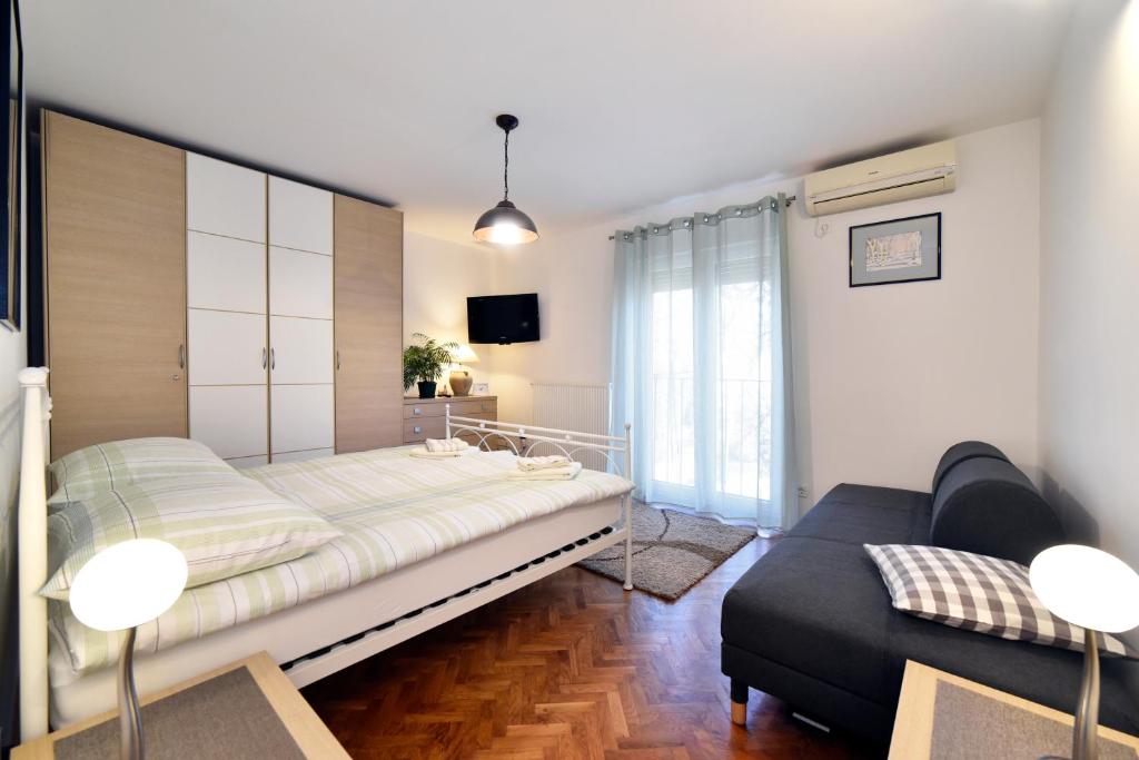 萨格勒布Apartman Nola的一间卧室配有一张床和一张沙发