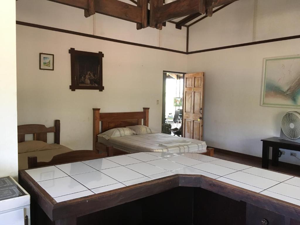 CurubandéTiquisia Lodge的客厅配有两张床和一张桌子