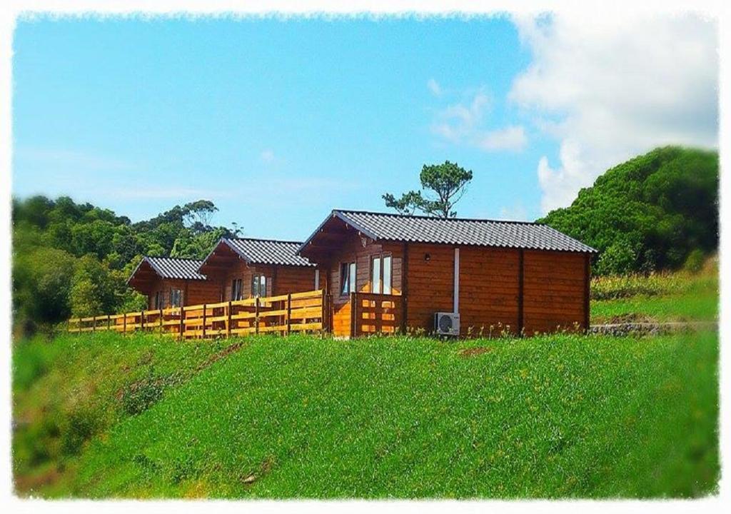 韦拉斯São Jorge Spot - Alojamento的田野上山丘上的木屋
