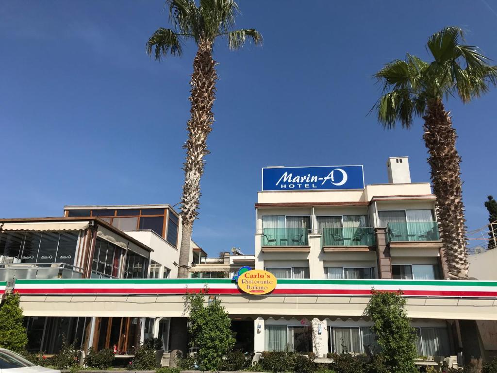 图尔古特雷斯Marin-A Hotel & Spa Turgutreis的一座棕榈树环绕的大建筑