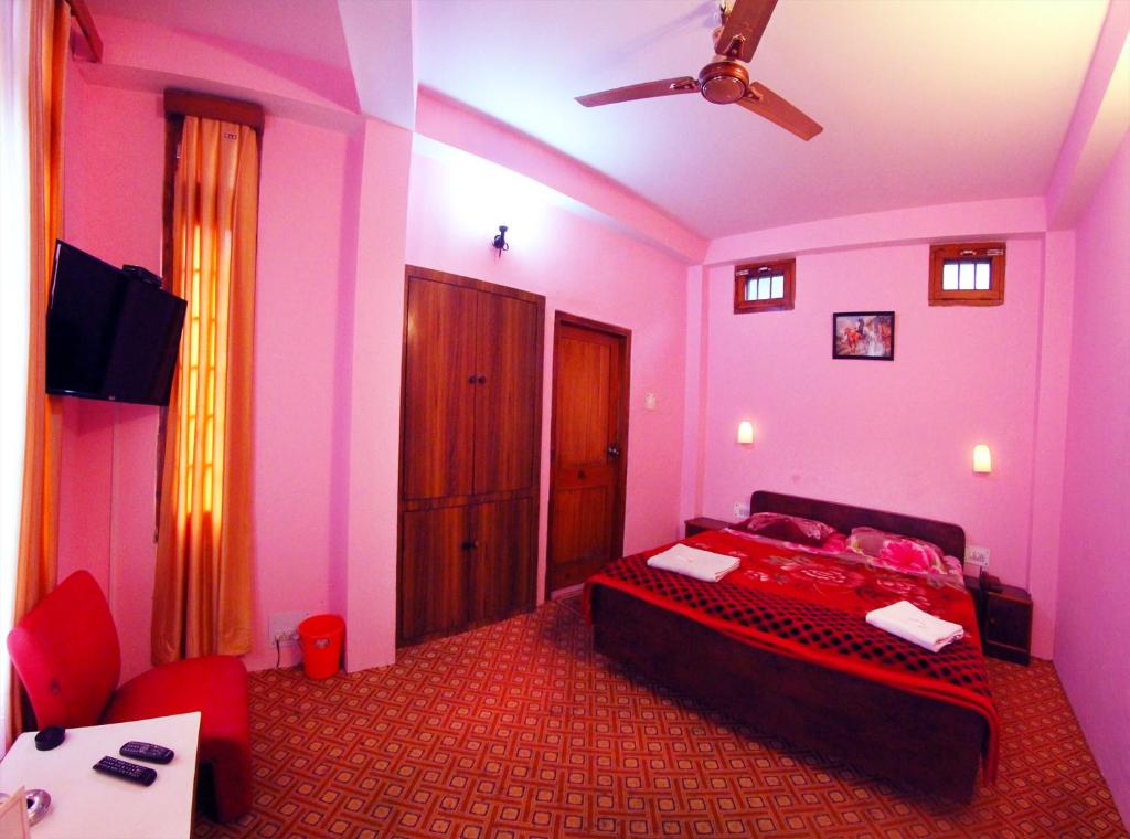 库尔卢Hotel Aroma Classic的一间卧室配有一张床和吊扇
