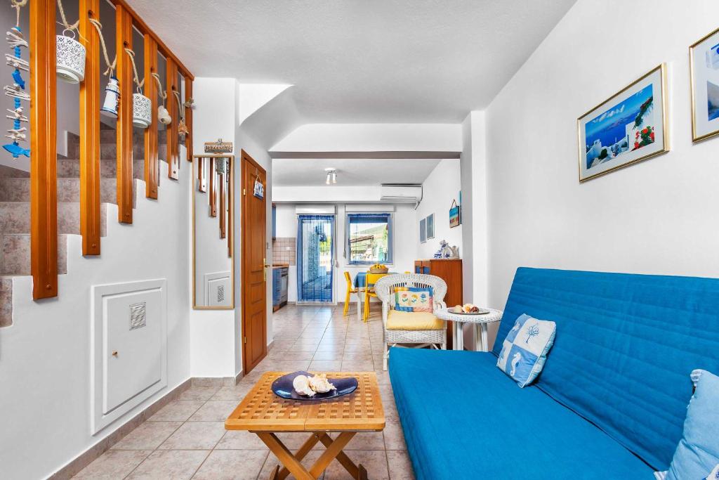 耶拉基尼Gerakini Sunshine Holiday Homes的客厅配有蓝色的沙发和桌子