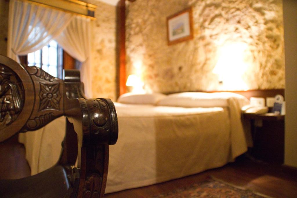 萨拉曼卡Hotel Microtel Placentinos的一间卧室配有一张床和一张带台灯的桌子