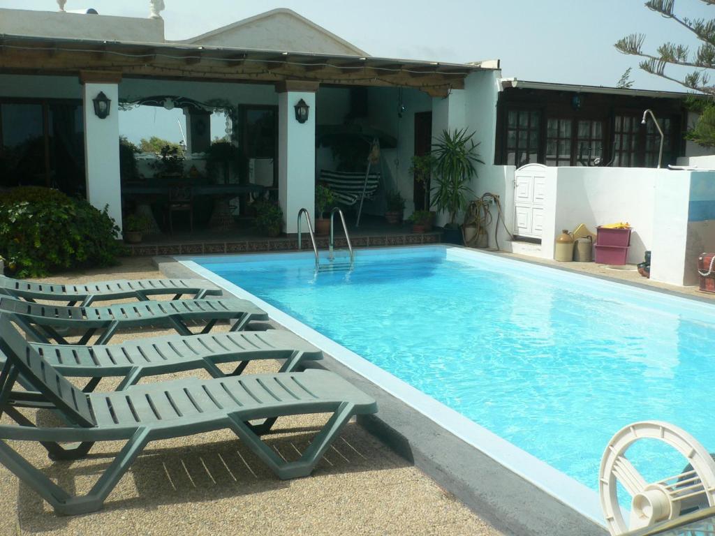 塔伊切Casa Albryna Lanzarote Rural Villa, Pool Wifi的一个带躺椅的游泳池以及一座房子