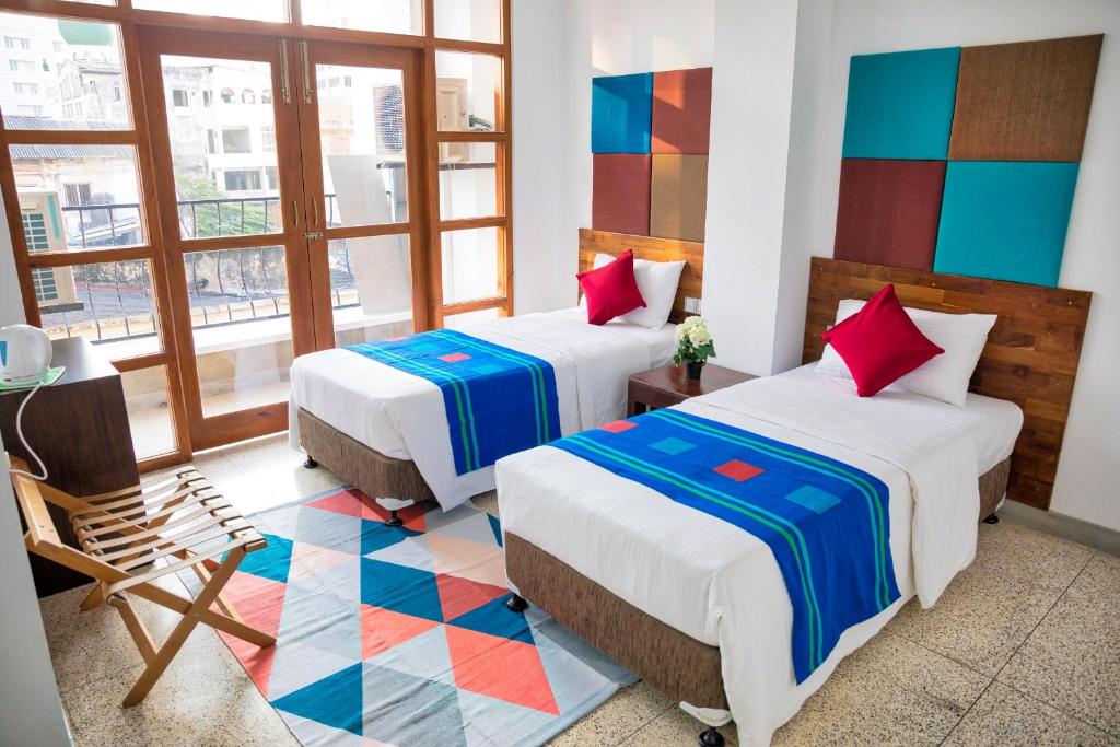 科伦坡科伦坡堡C1酒店的酒店客房,配有两张床和椅子