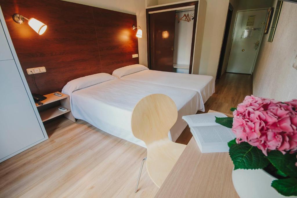 阿尔么丽亚伊姆巴加多酒店的卧室配有白色的床和粉红色玫瑰