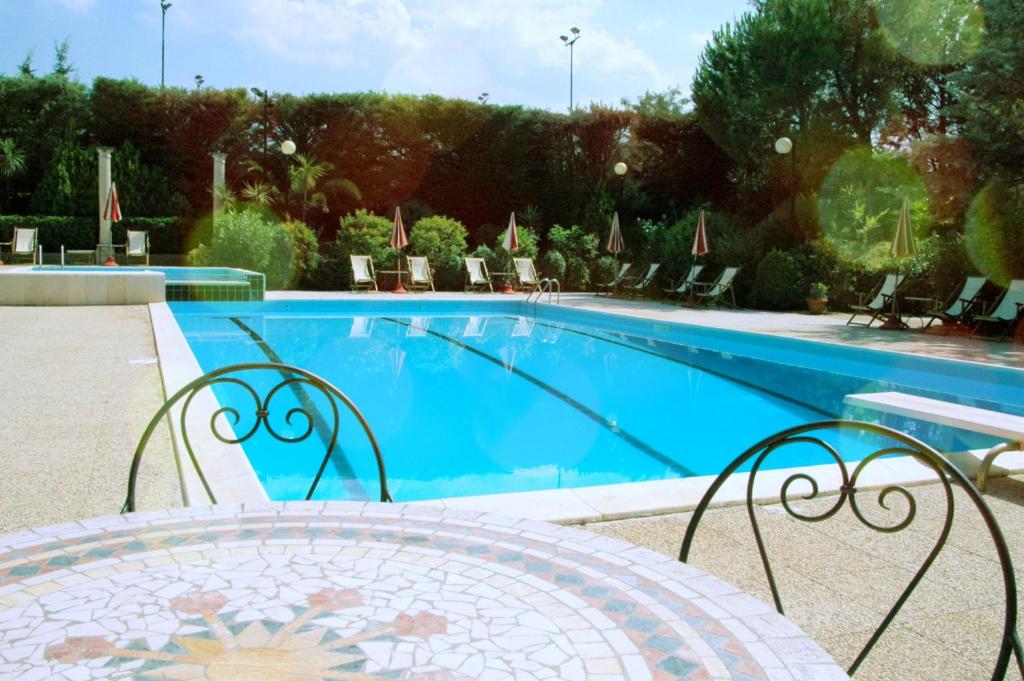 维耶斯泰Residence Villa Agrimare的游泳池旁设有桌椅