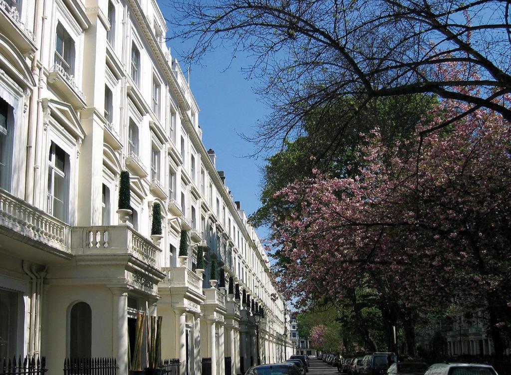 伦敦凯撒酒店的一条有白色建筑和花卉树的城市街道