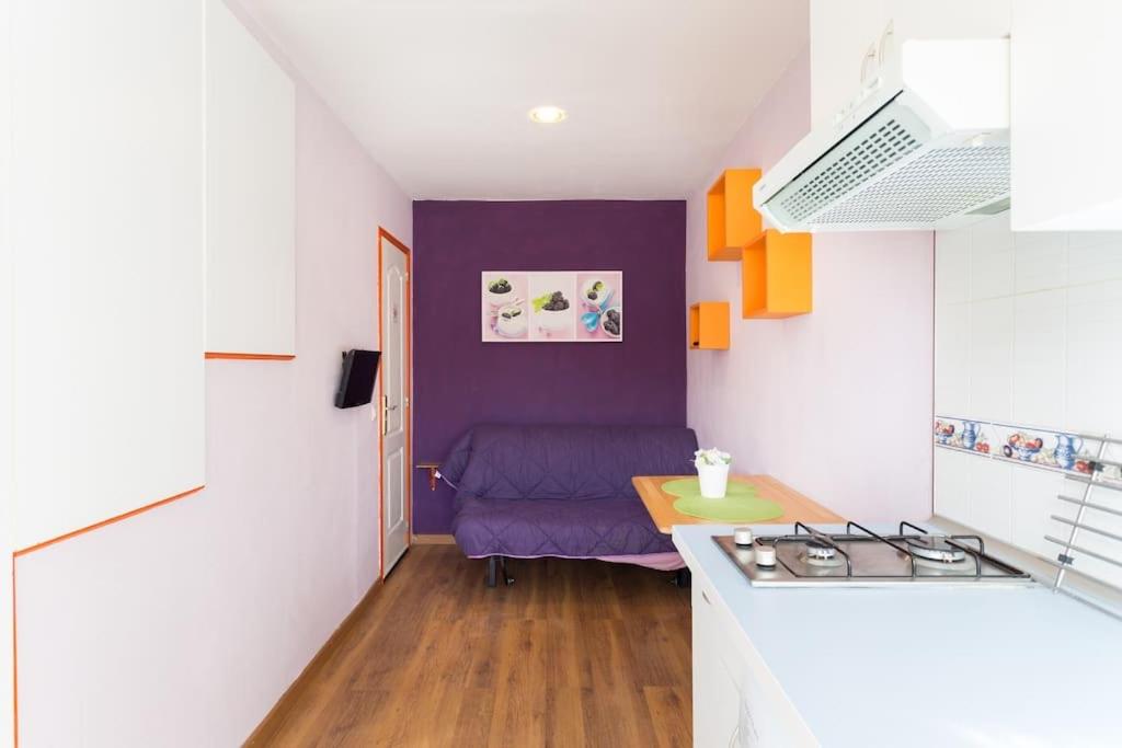 圣伊西德罗Estudio moderno y acogedor, a 5 minutos de la playa的厨房配有紫色沙发和桌子