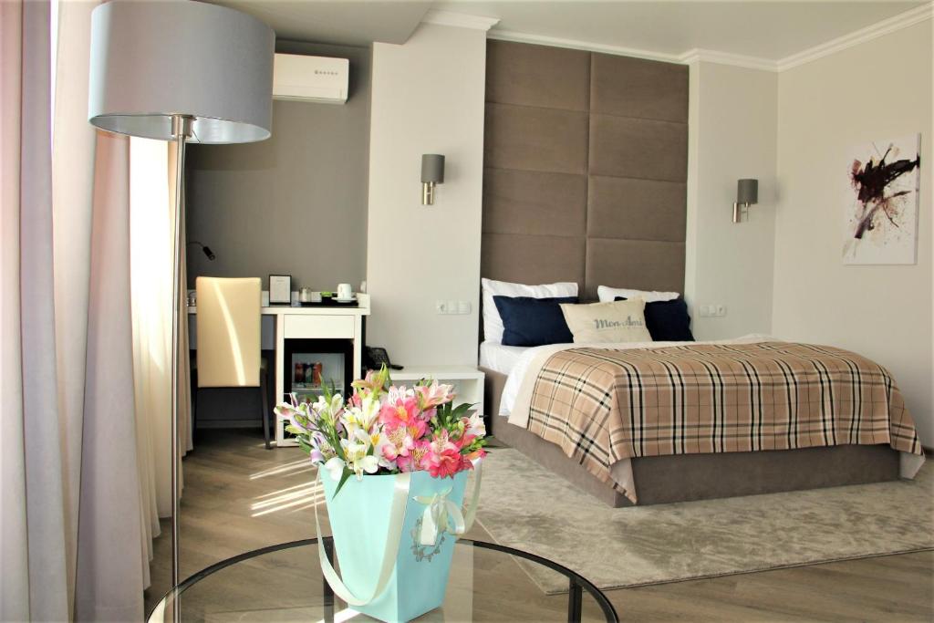 基希讷乌Mon Ami Villa的一间卧室配有一张床和一张鲜花桌