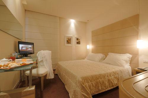 卡莱扎诺福斯特酒店的一间卧室配有一张床和一张书桌及电视