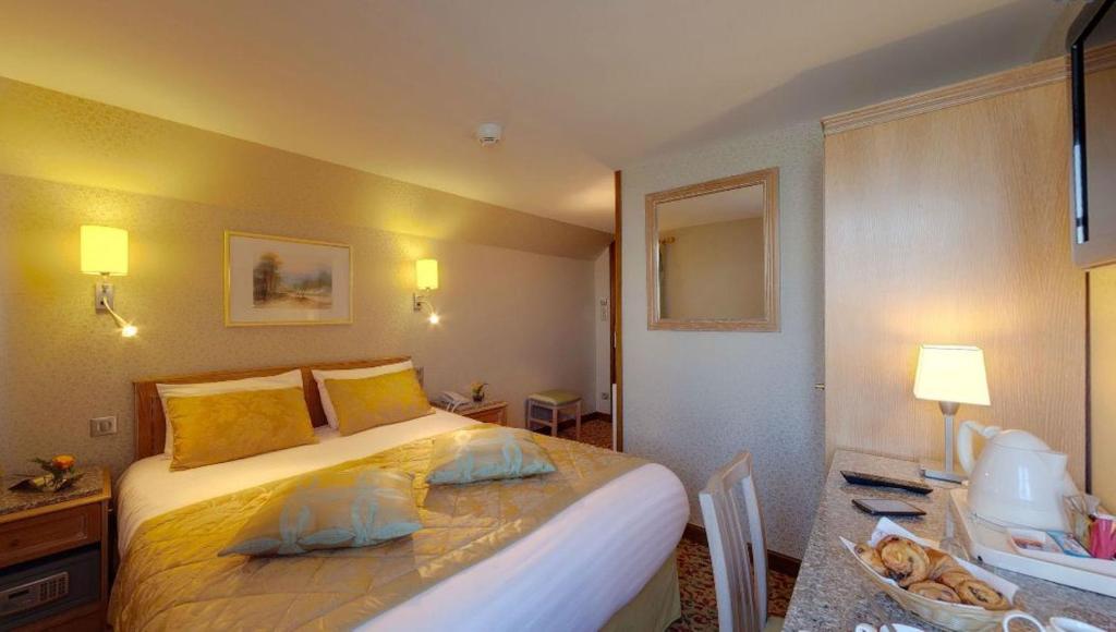 圣米歇尔山克洛伊克斯布兰奇酒店的酒店客房配有一张床、一张书桌和一张四柱床