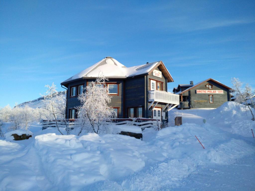 基尔匹斯扎我维Arctic Polar Holiday Village的前面的雪覆盖的房子