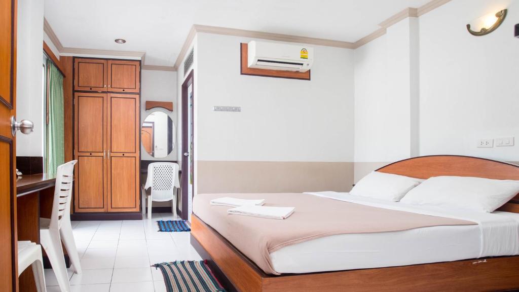 芭东海滩DJ House ดีเจ เฮ้าท์ป่าตอง的一间带一张床和一张书桌的卧室和一间厨房