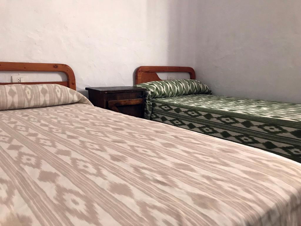 圣米格尔德阿沃纳Casa Maria Luisa的一间卧室配有两张床和两把椅子