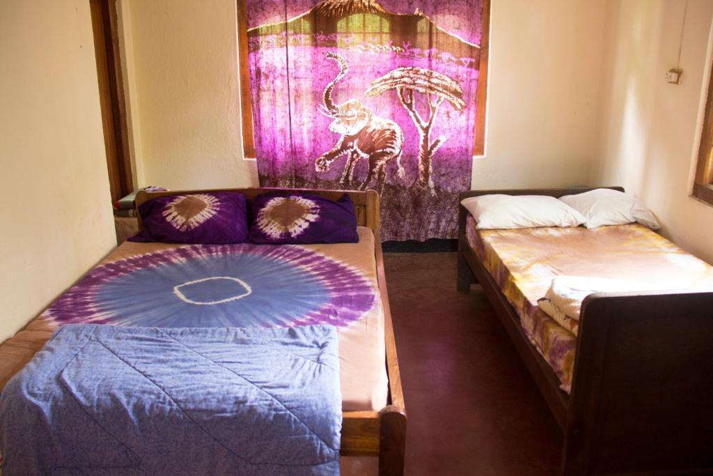 MachameMachame Nkweshoo Cultural Tourism的一间设有两张床和一张沙发的房间