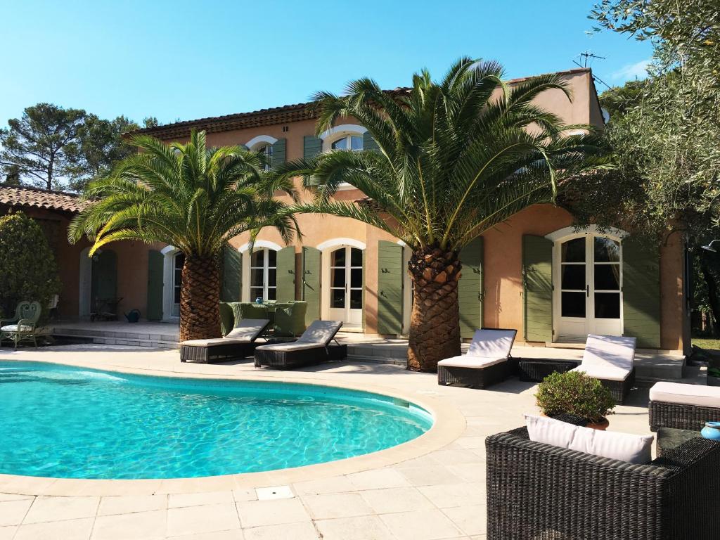 La Roquette-sur-Siagne勒前埔马泽特住宿加早餐旅馆的棕榈树屋前的游泳池
