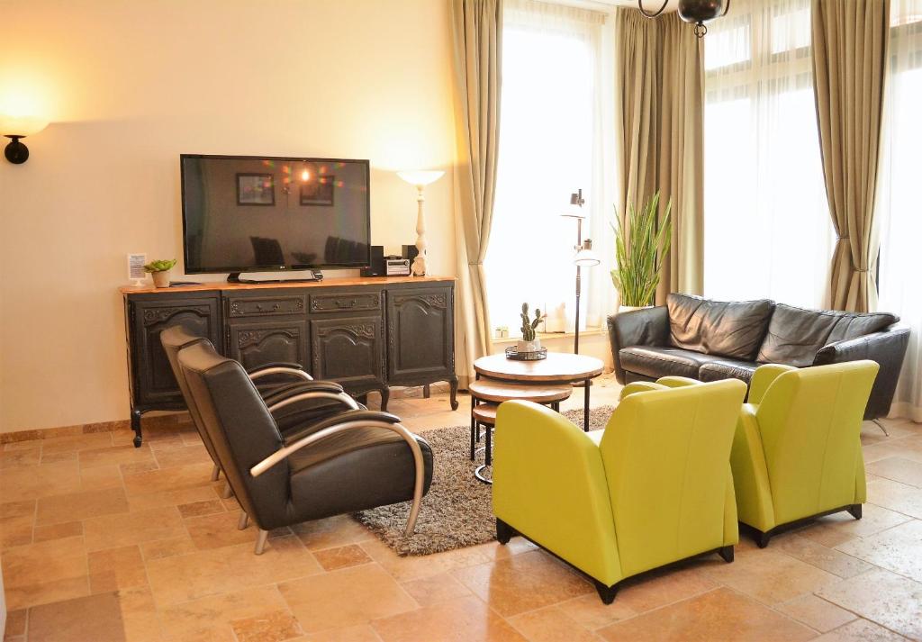 栋堡DAC50 Luxurious apartment Domburg的客厅配有沙发、椅子和电视