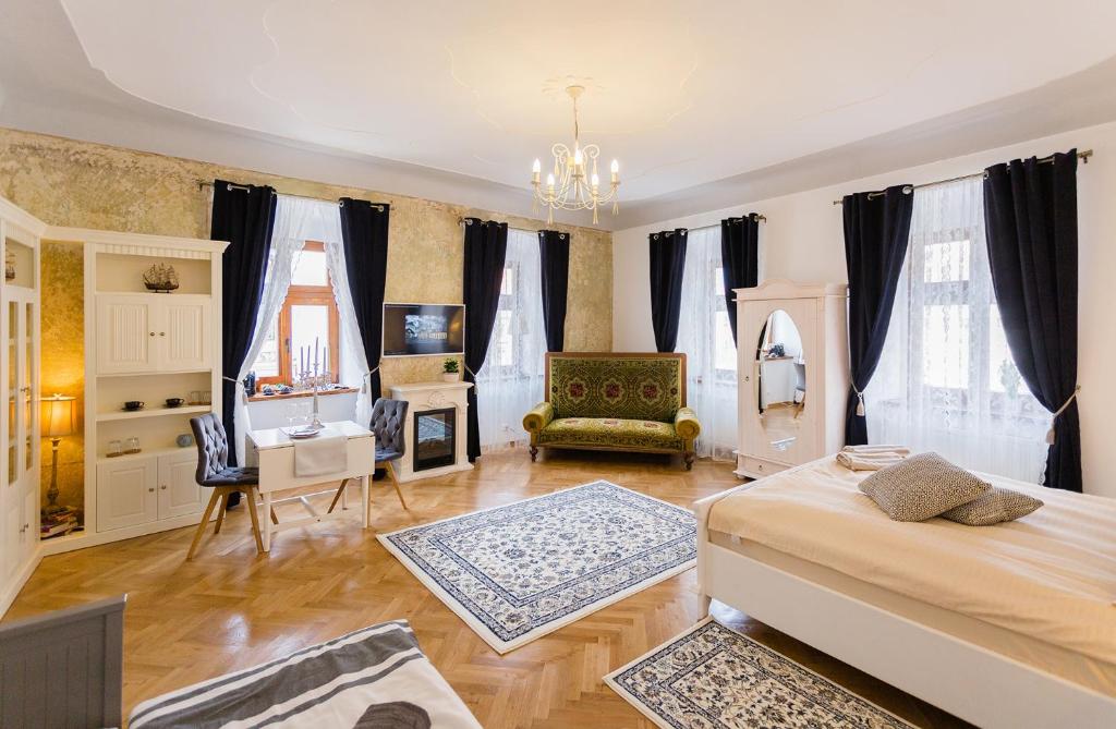 锡比乌Crown Jewels Centre Sibiu的一间卧室配有一张床、一把椅子和一张书桌