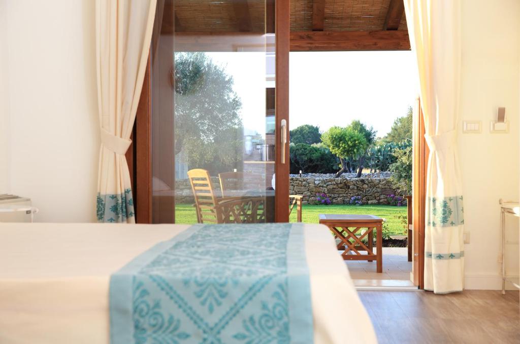 圣塔·马里亚·迪·帕尔玛Inghirios Wellness Country Resort的卧室配有一张床,享有庭院的景色