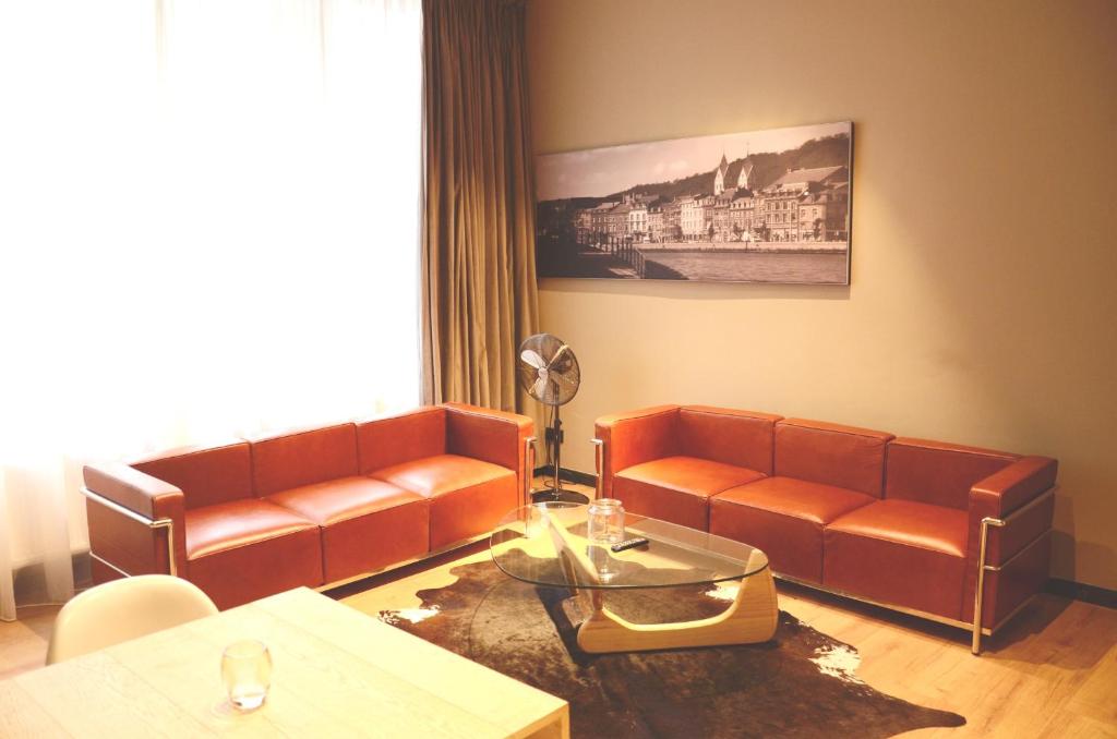 列日Amosa Liège City Centre Apart Donceel 6的客厅配有两张真皮沙发和一张桌子