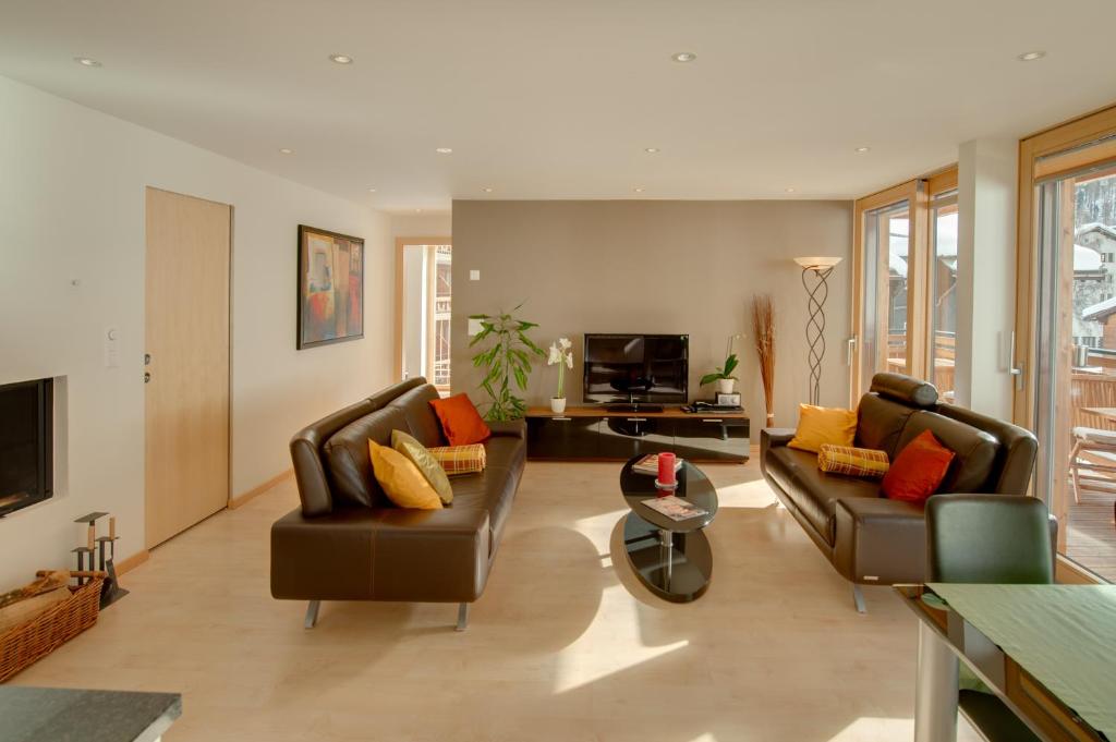 采尔马特梅里克高级公寓的客厅配有两张沙发和一台电视