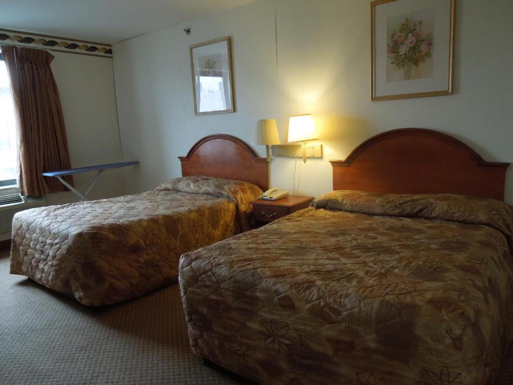 布鲁克林布鲁克林红地毯酒店的酒店客房设有两张床和一张桌子。