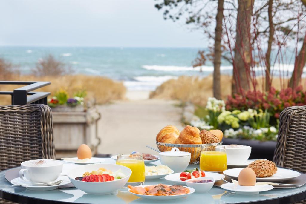 蒂门多弗施特兰德芳塔纳斯特瑞德酒店的一张桌子上放着食物和鸡蛋,上面放着水果