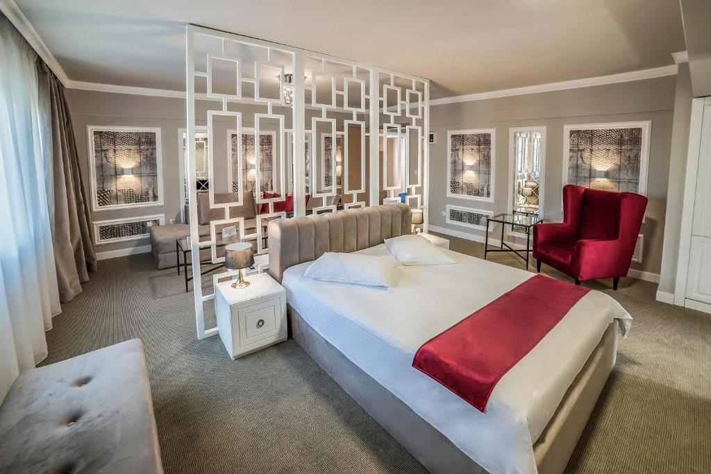 蒂米什瓦拉Hotel Boavista的一间卧室配有一张大床和一张红色椅子