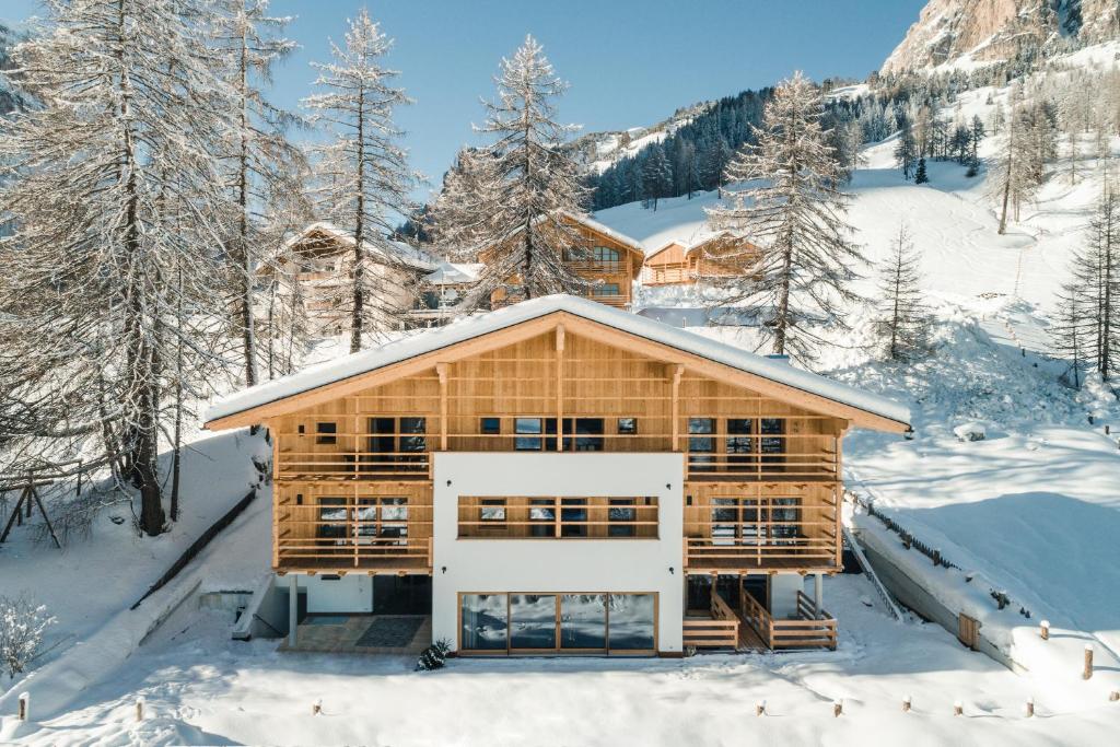 科尔福索鲁恩木屋乡村民宿的雪地里的小木屋,有雪覆盖的树木