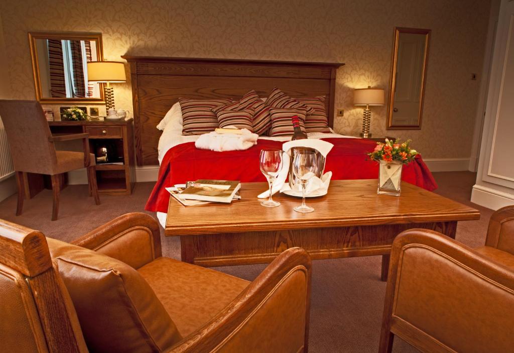 洛夫特斯格林科勒公园酒店的酒店客房,配有床和桌子,配以酒杯