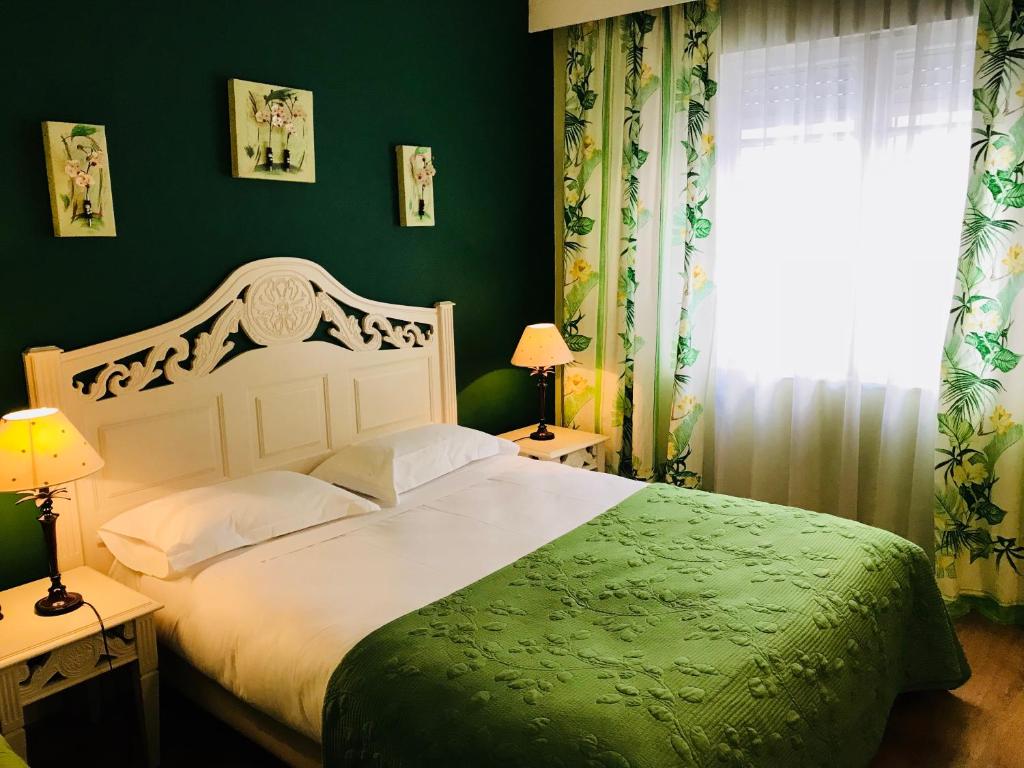 戛纳菲斯蒂瓦酒店的卧室配有白色的床和绿色的墙壁