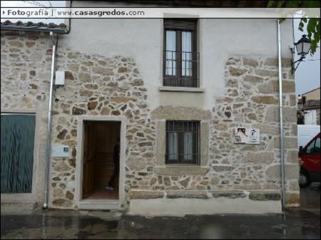 Los Llanos de TormesCasa Rural La Antigua Fragua的一座石头建筑,设有门和两扇窗户