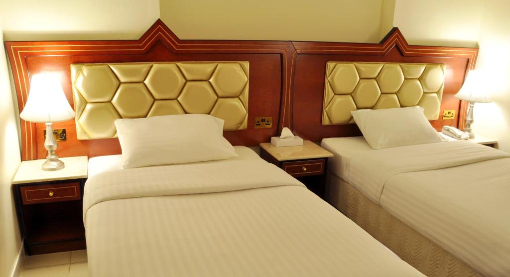 迪拜萨夫荣酒店的酒店客房设有两张床和两盏灯。