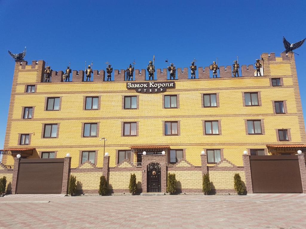 沃罗涅什Hotel Zamok Korolya的一座黄色的大建筑,上面有人