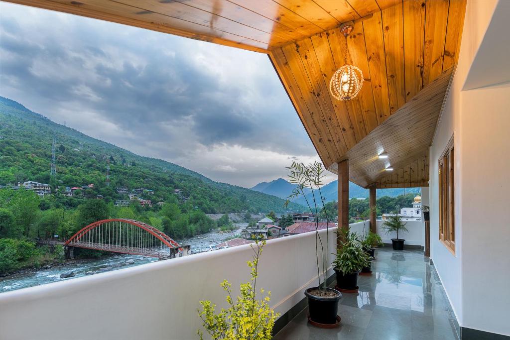 库尔卢Hotel Kullu Valley的享有河流和桥梁景致的阳台