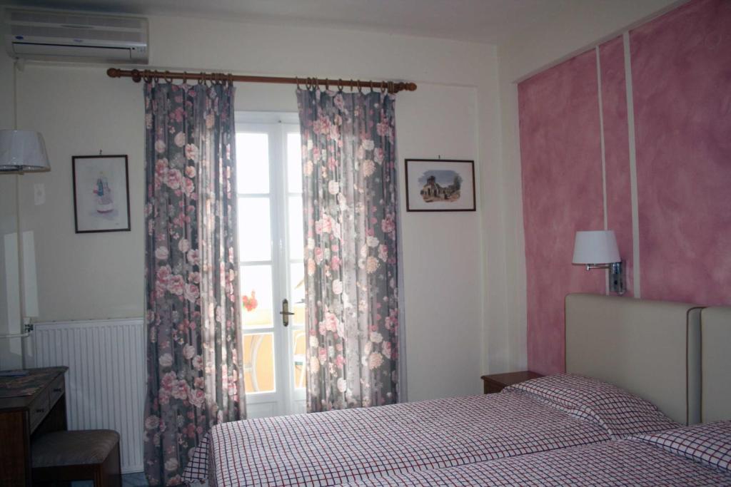 格利法达Georgia Apartments & Studios Corfu的一间卧室配有床和带窗帘的窗户