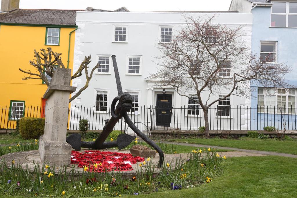 莱姆里吉斯Monmouth House Apartments, Lyme Regis Old Town, dog friendly, parking的建筑前花园中的雕像