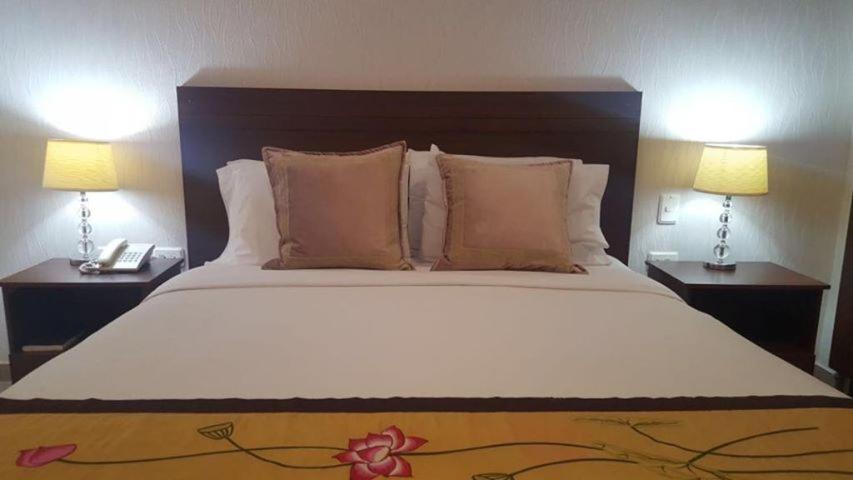 San Juan del CesarCasa Murillo Hotel的一间卧室配有一张大床和两盏灯