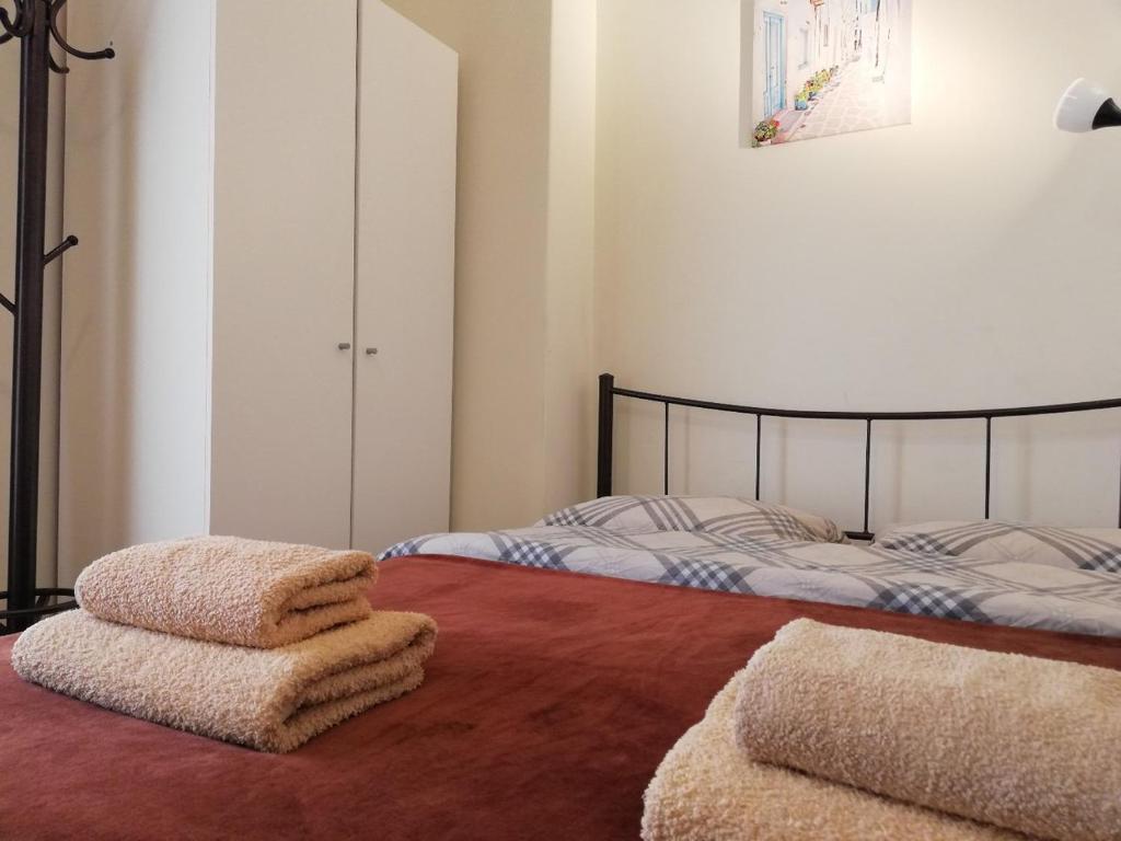 雅典斯夫格斯54旅馆的卧室配有两张床和毛巾,位于地板上