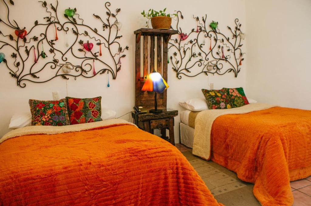 拉戈斯德莫雷诺泰特卡索娜酒店的一间卧室配有两张带橙色棉被的床