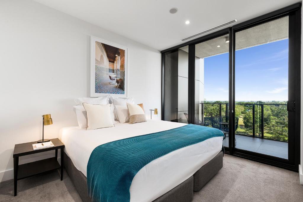 墨尔本泰尔阿尔伯特公园湖公寓的一间卧室设有一张大床和一个大窗户
