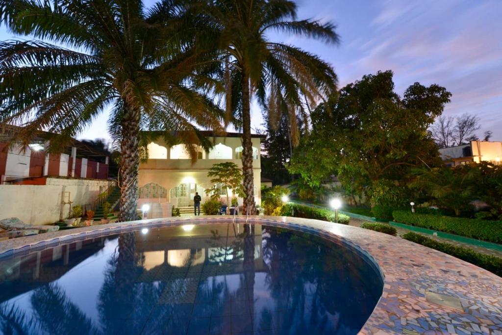 Bakau世界大同旅馆的一座房子前面的游泳池,两棵棕榈树