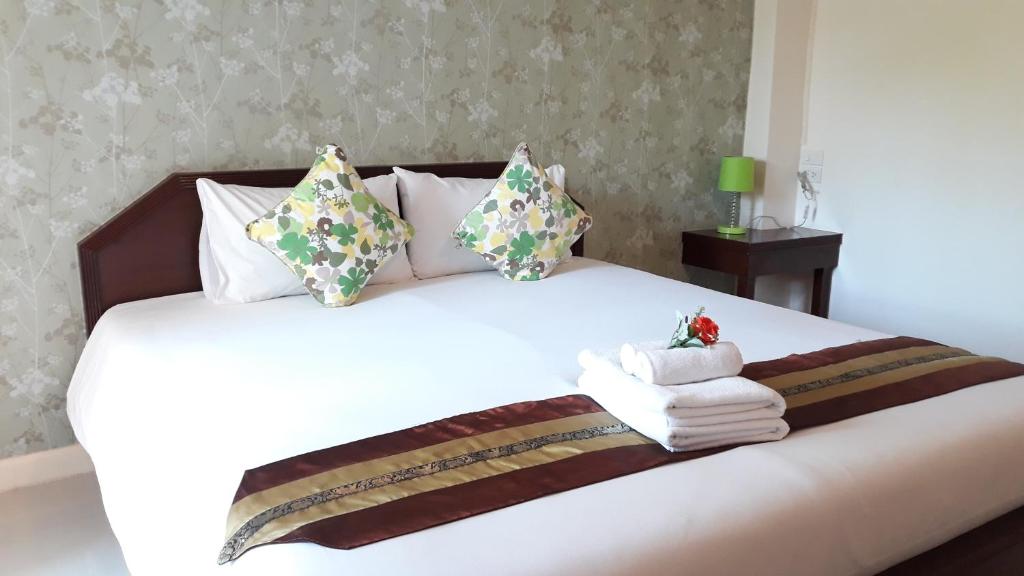 春蓬春蓬旅游酒店的卧室配有白色床和毛巾
