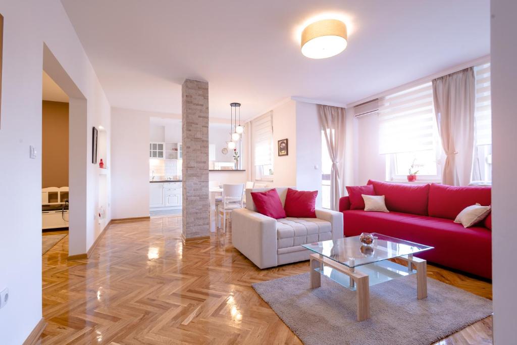 诺维萨德Apartman Arte的客厅配有红色的沙发和桌子