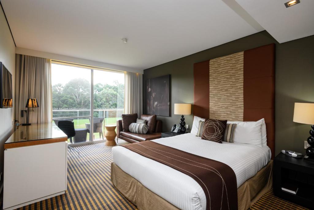 悉尼MGSM行政酒店及会议中心的酒店客房设有一张大床和一张沙发。