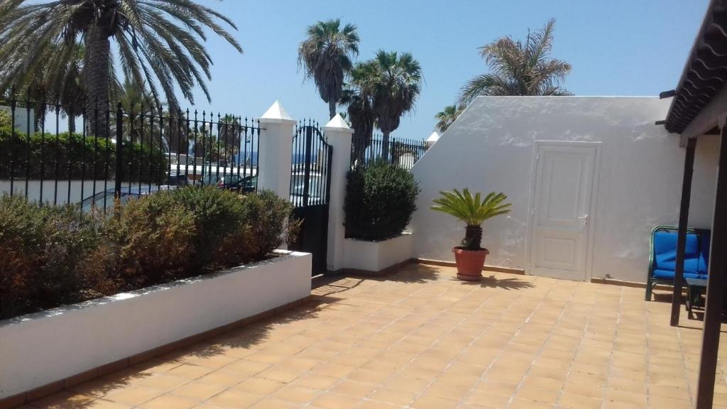 卡门港Casa Tiati的庭院设有白色的围栏和棕榈树