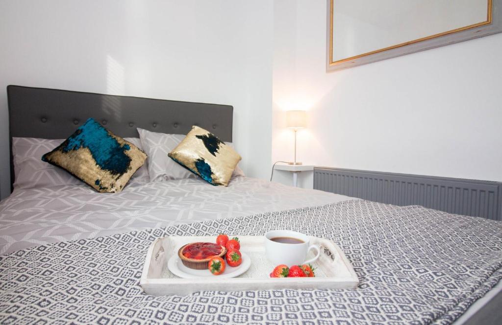 埃克塞特Magdalen Quarters的床上的水果盘和咖啡