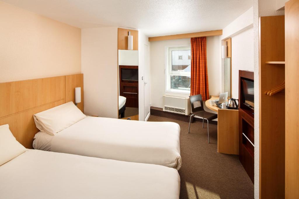 伯明翰伯明翰中心新街站宜必思酒店的酒店客房配有两张床和一张书桌